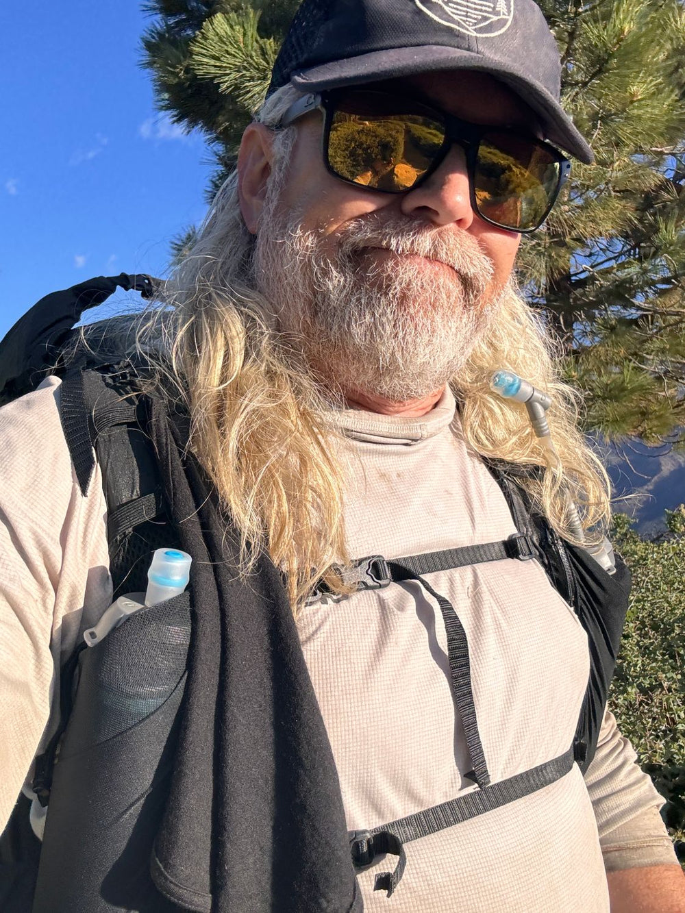 Shane Petersen of Glacial Gear on trail with a black Trail Rag draped over his pack’s shoulder strap