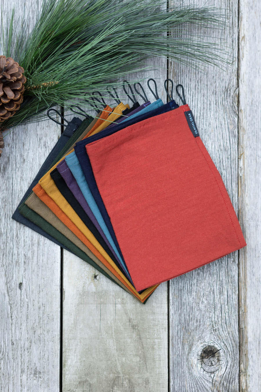 Glacial Gear Trail Rag Classic towels stacked in assorted colors on weathered wood