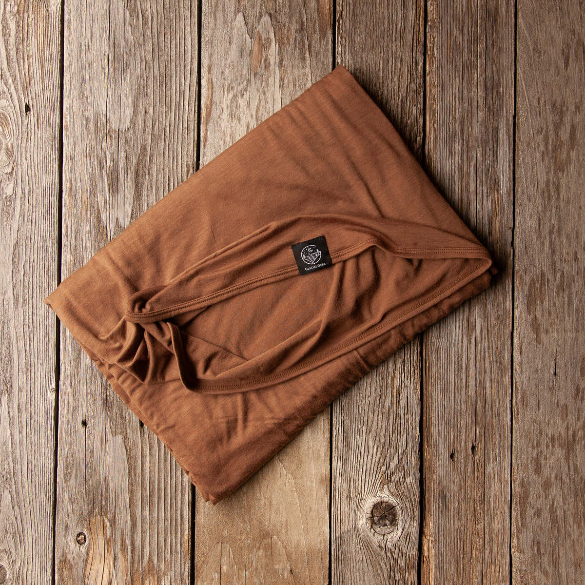 Folded Bark brown Glacial Gear ultralight Merino wool blanket on rustic wood