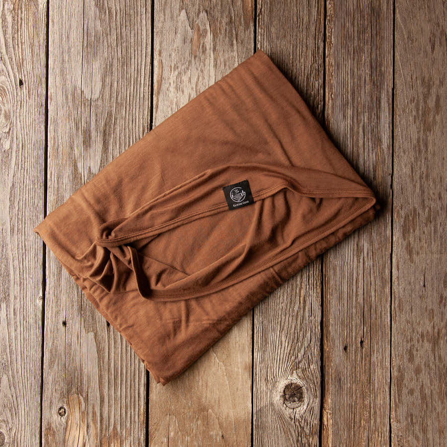 Folded Bark brown Glacial Gear ultralight Merino wool blanket on rustic wood