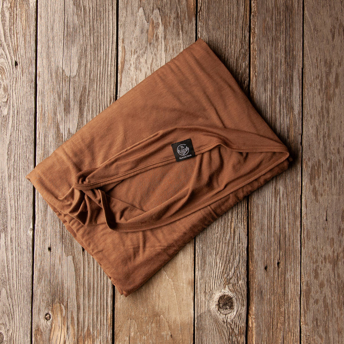 Folded Bark brown Glacial Gear ultralight Merino wool blanket on rustic wood