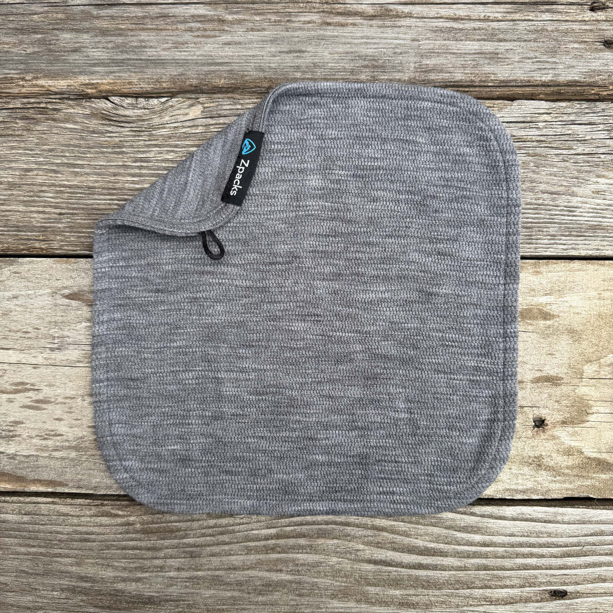 Gray Glacial Gear x Zpacks Merino Trail Rag with one corner folded to show its hanging loop