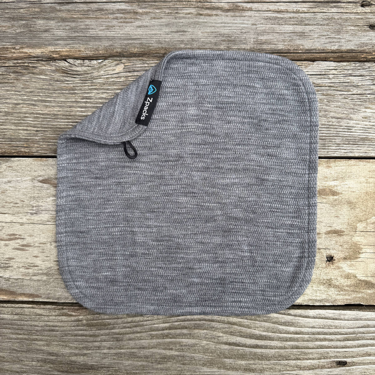 Gray Glacial Gear x Zpacks Merino Trail Rag with one corner folded to show its hanging loop