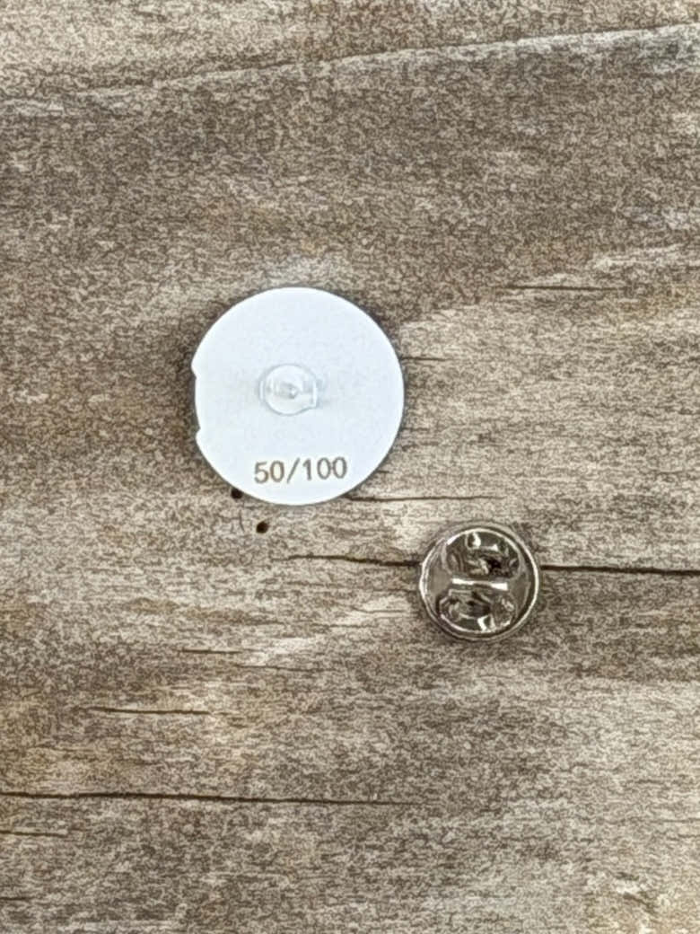 Back of the Glacial Gear enamel pin, numbered 50/100, with its pin back beside it