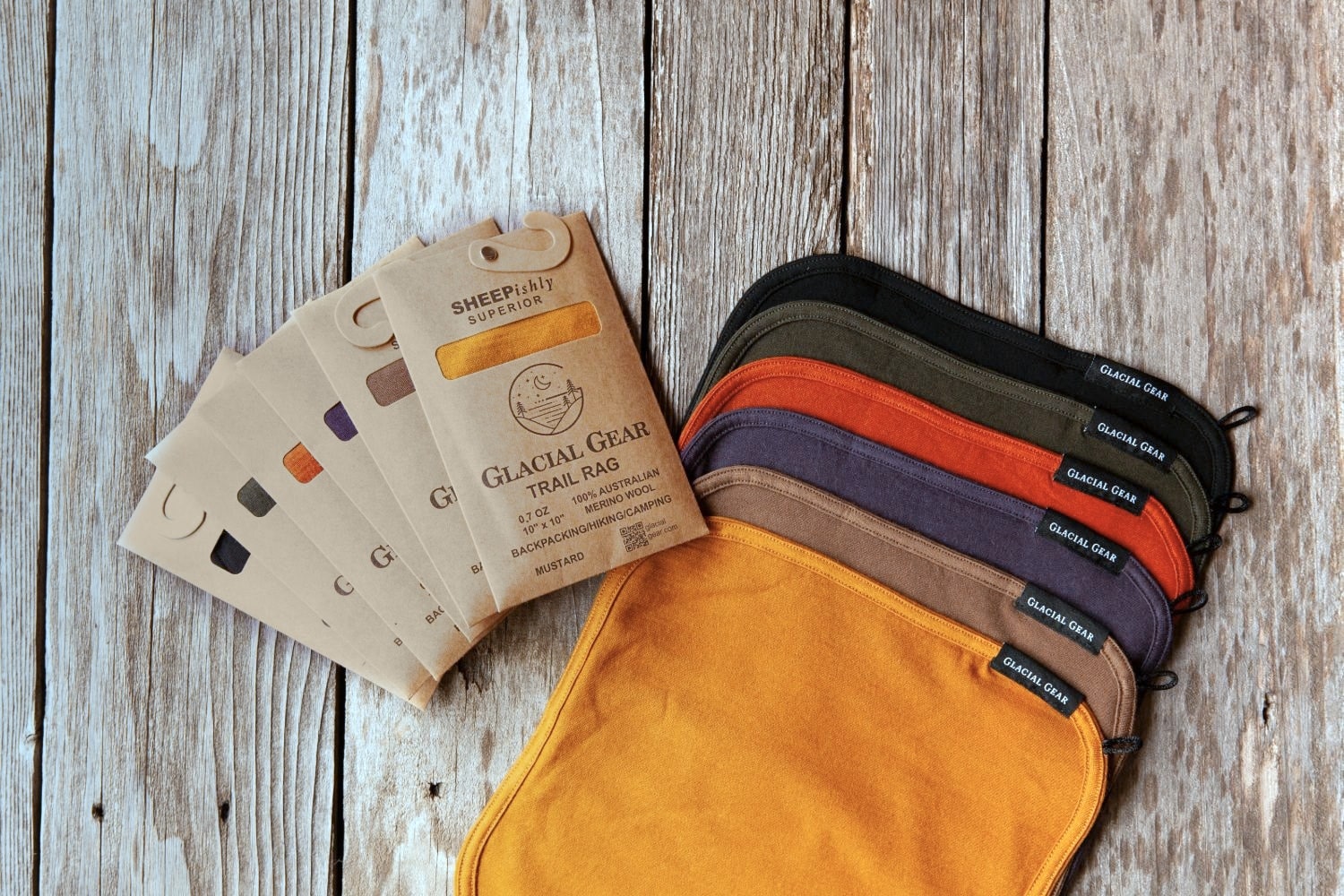 Six Glacial Gear Trail Rags fanned out beside their kraft retail packs, one pack for each color