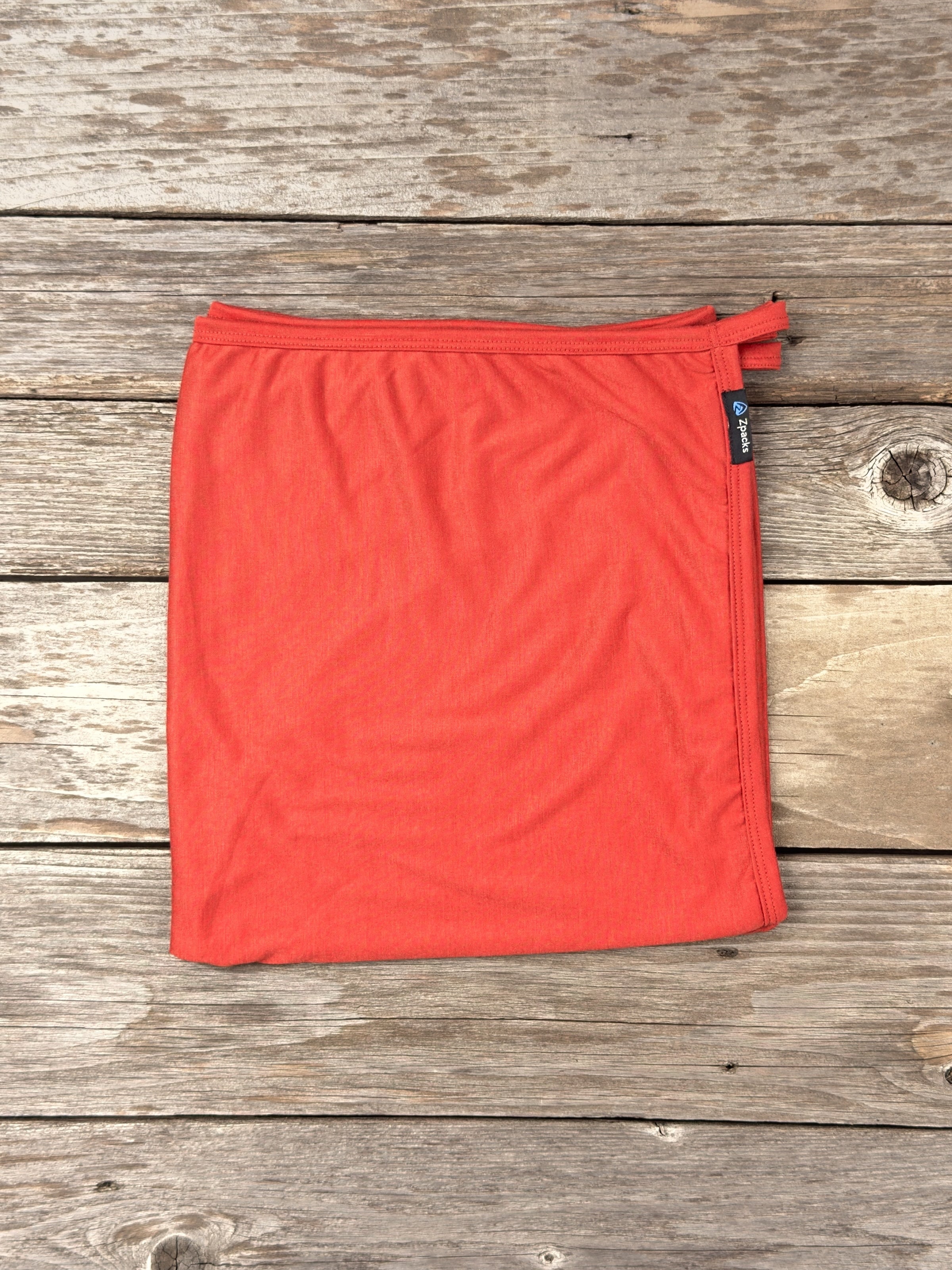 Large Autumn Glacial Gear x Zpacks Camp Towel, folded on weathered wood