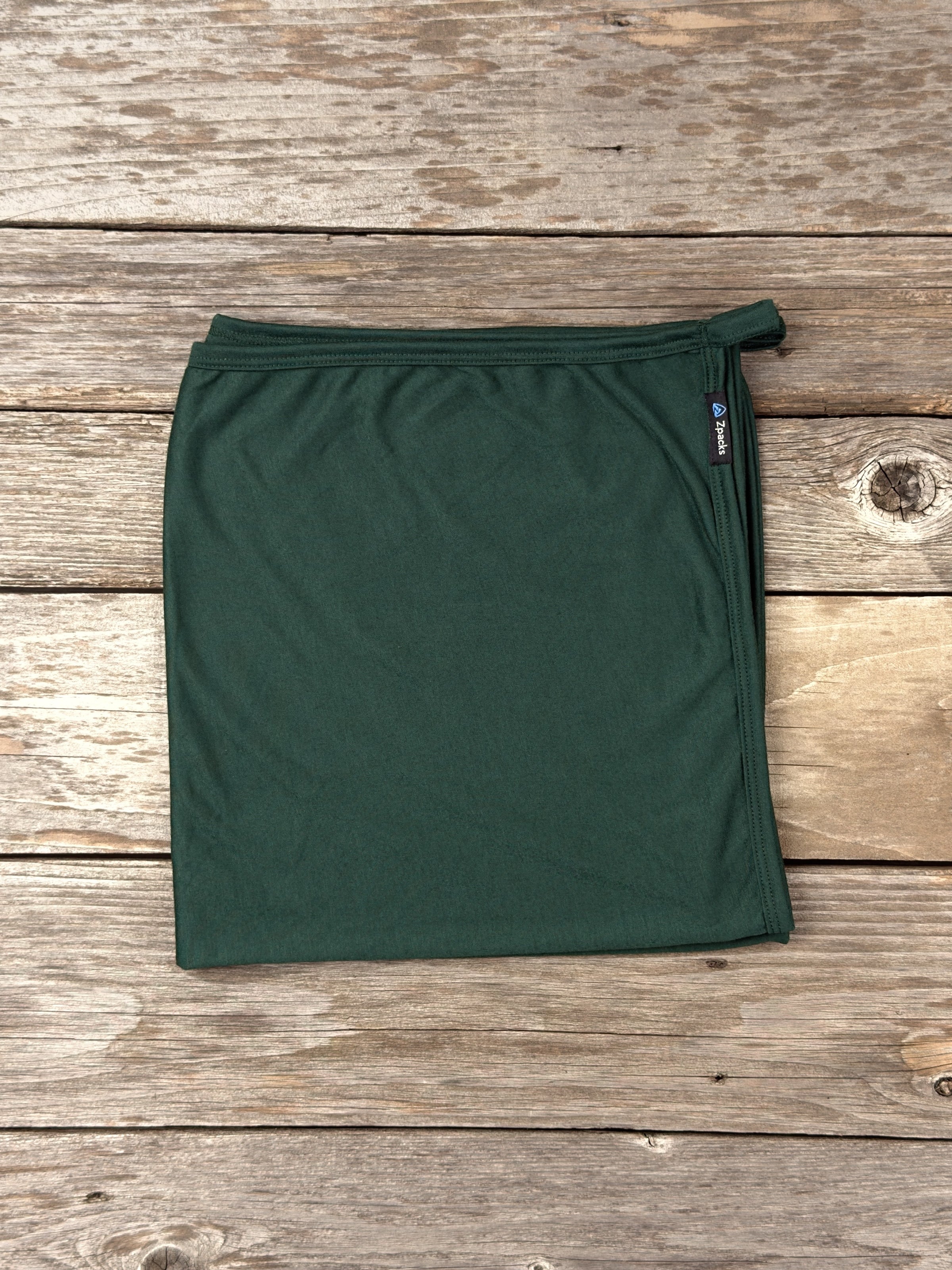 Large Forest Glacial Gear x Zpacks Camp Towel, folded on weathered wood
