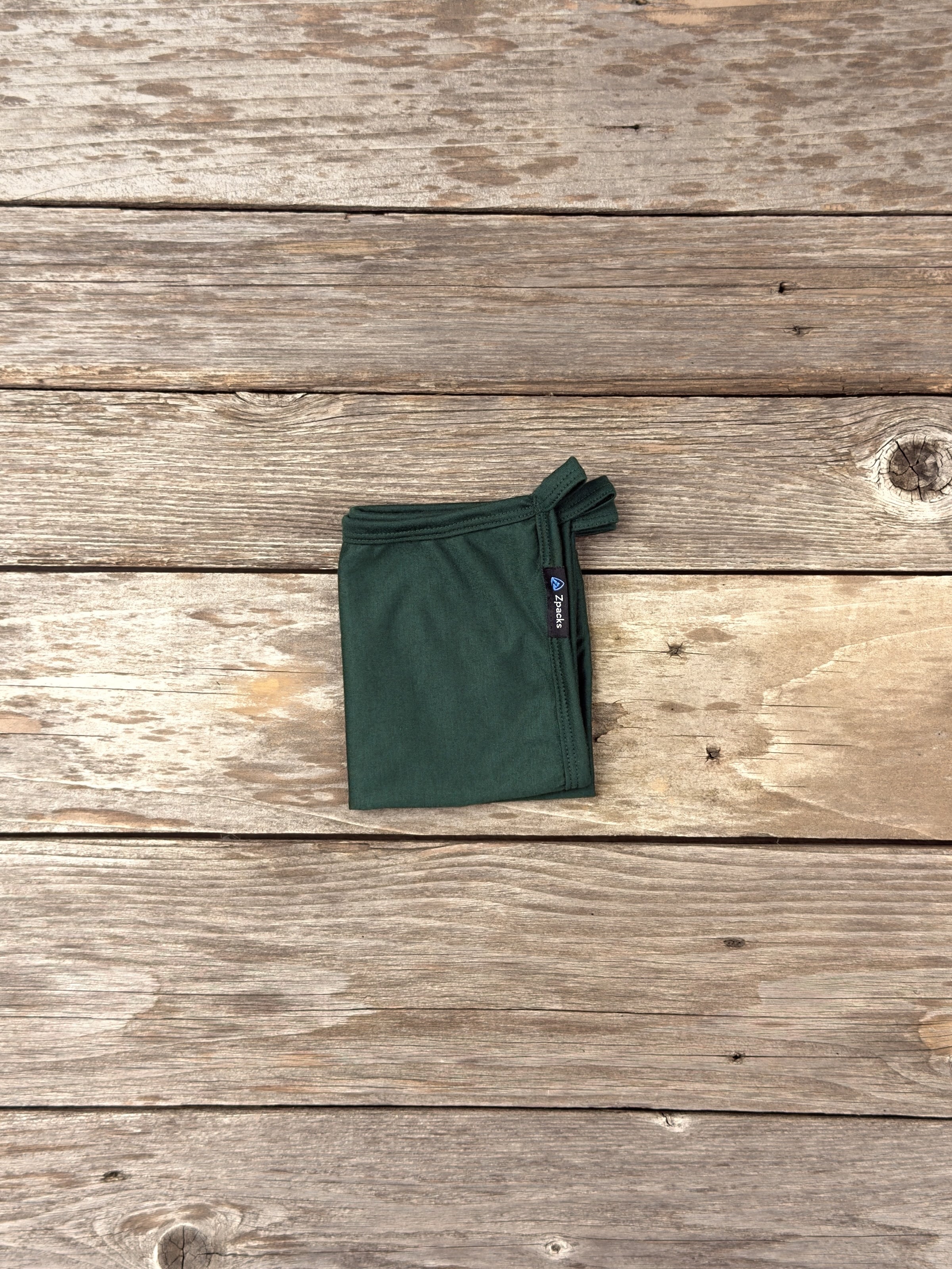 Small Forest Glacial Gear x Zpacks Camp Towel, folded on weathered wood