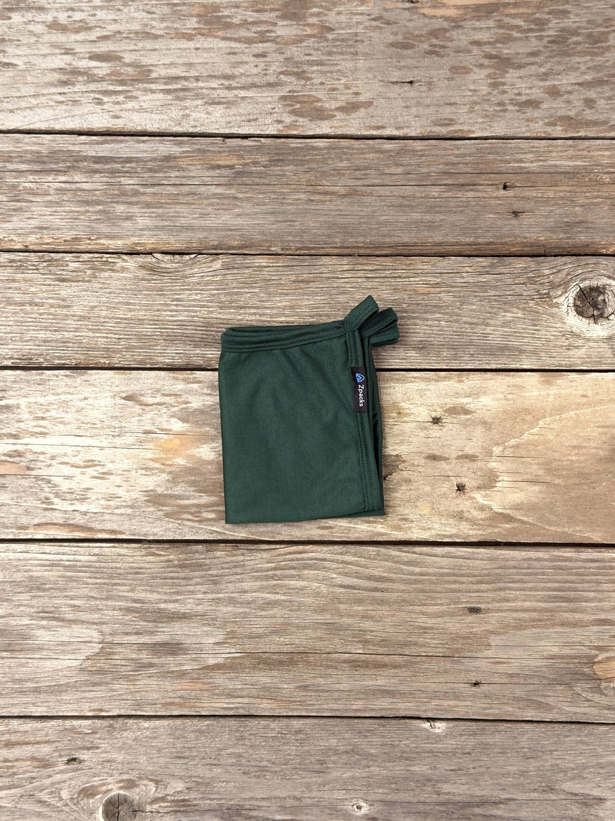 Small Forest Glacial Gear x Zpacks Camp Towel, folded on weathered wood