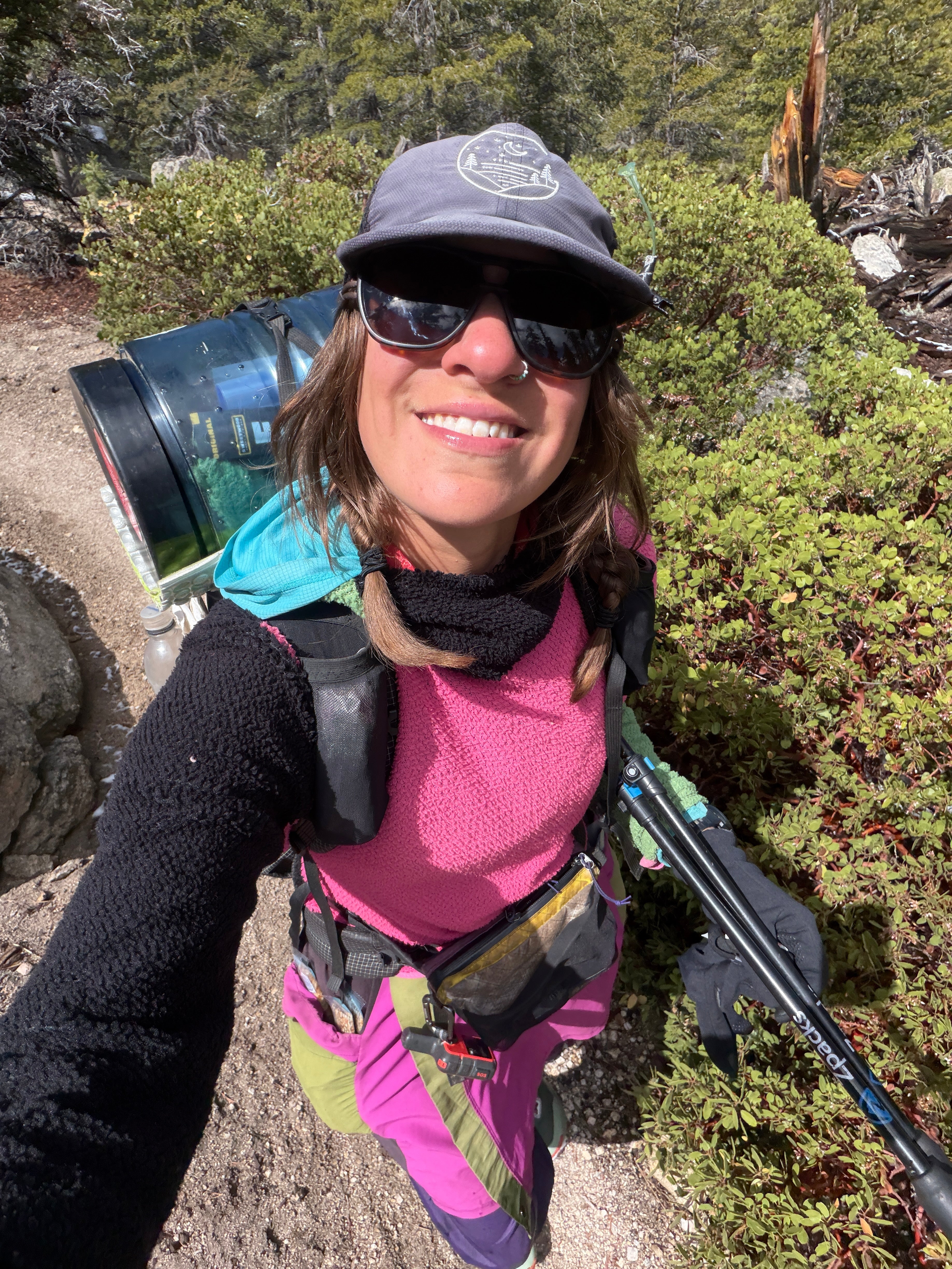 Jocelyn Smith wearing her well-used Glacial Gear Foldable Trail Hat on a sunny forest trail