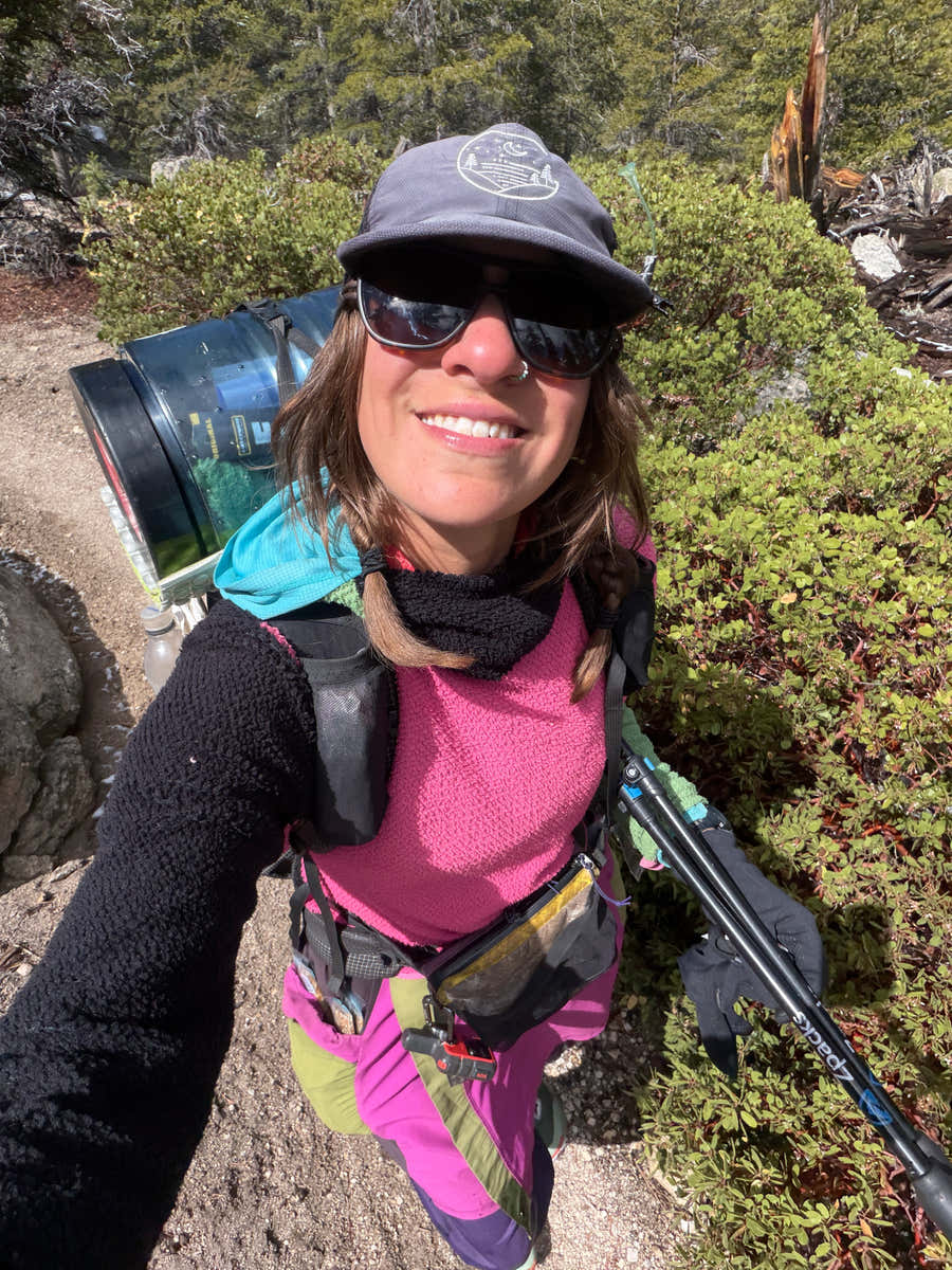 Jocelyn Smith wearing her well-used Glacial Gear Foldable Trail Hat on a sunny forest trail