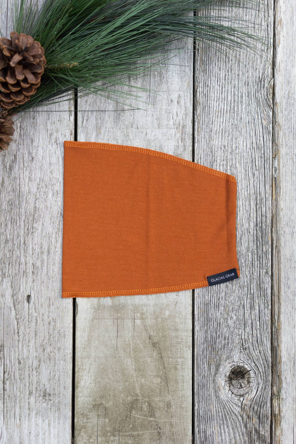 Paprika orange Ultralight Glacial Gaiter laid flat on weathered wood