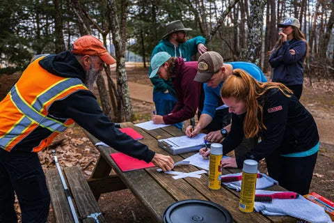 Volunteers signing in at a picnic table for a Responsible Stewardship event